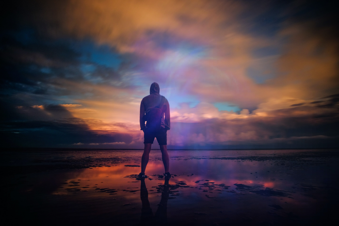 man standing on beach by Zoltan Tasi
