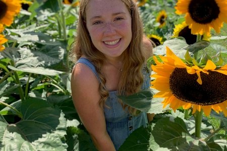 woman smiling with sunflowers