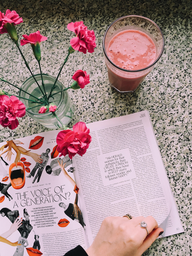 Open magazine with flowers and smoothie.