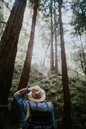 admiring hiking girl with hat and backpack