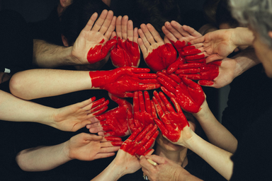 Many pairs of hands group together and painted to show a heart in the middle