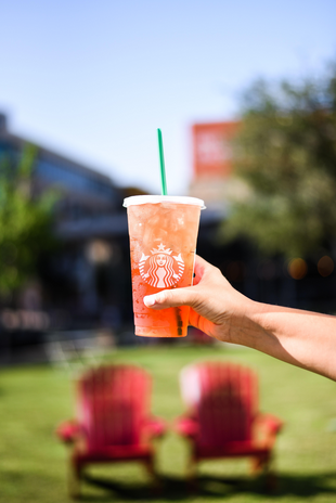 Hand holding pink Starbucks drink outside