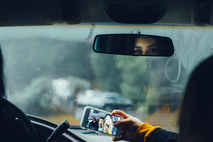 person taking selfie in car by Omar Lopez via Unsplash