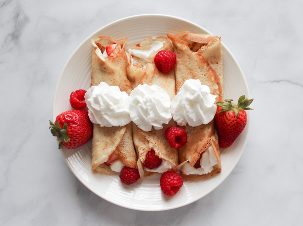 Crepes topped with berries and whipped cream