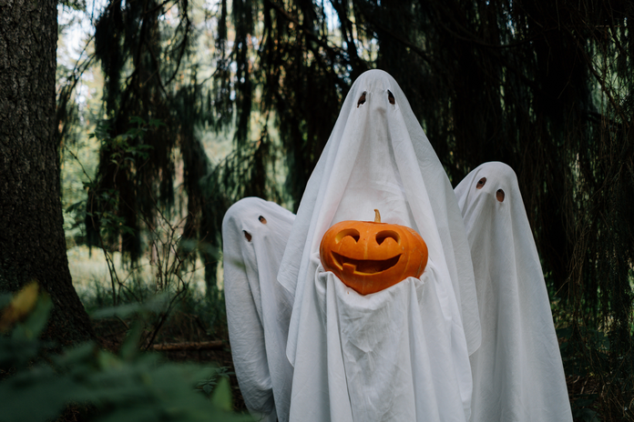 three bed sheet ghosts with a pumpkin by cottonbro