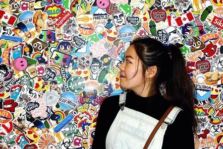 Emily Lin in front of sticker wall