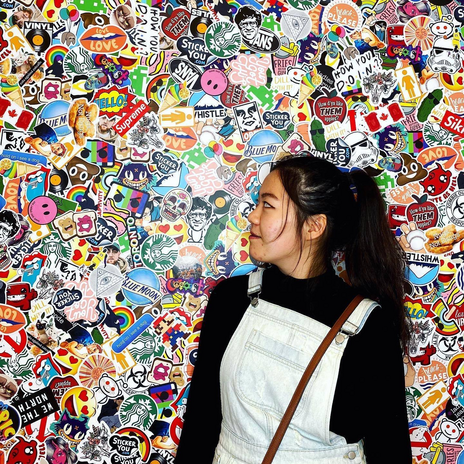 Emily Lin in front of sticker wall by Emily Lin