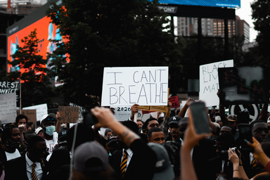 group of protesters with someone holding a sign that says "I can't breathe"