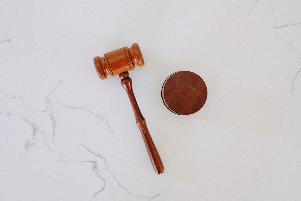 Wooden gavel on a white marble backdrop