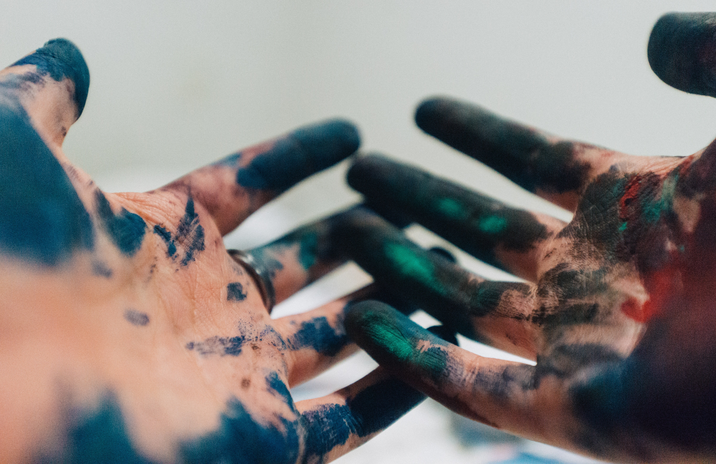two hands covered in paint by Amauri Meja