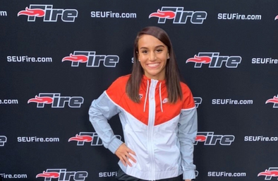 girl with red and white track jacket, posing and smiling.