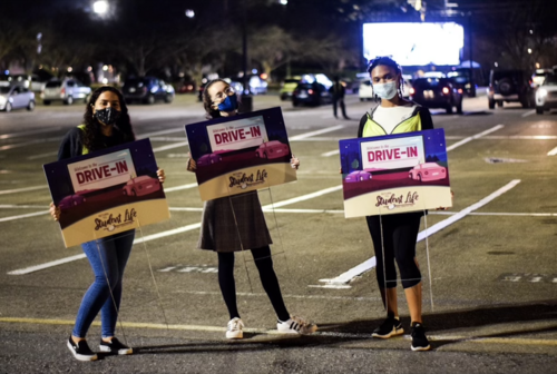 masked students with aslc drive in posters