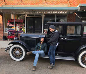 two set memebers with vintage car