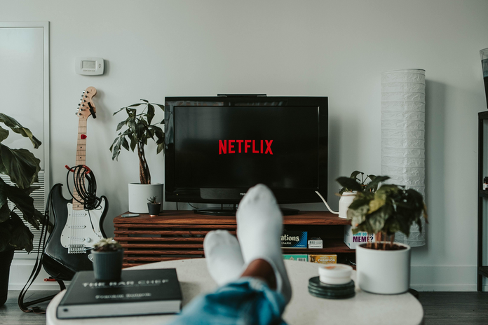 Netflix on the TV with feet (unsplash