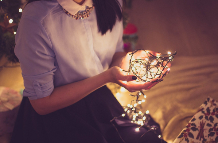woman holding christmas lights by StockSnap