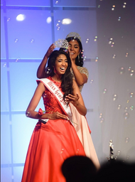 Girl is being crowned as Miss Georgia Teen on a red gown