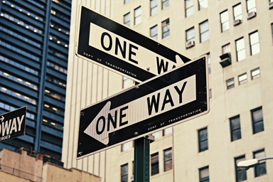 two street signs that say "one way" but point in opposite directions