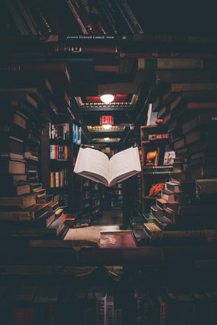 circle of books with book floating in center by Jaredd Craig on Unsplash
