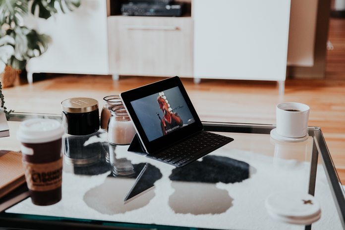 laptop on glass coffee table by Hannah Busing on Unsplash