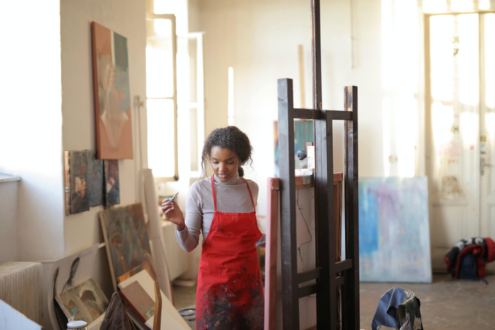 woman artist painting in studio by Andrea Piacquadio