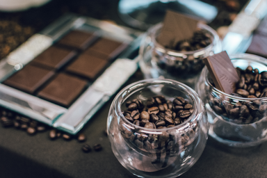 Cocoa beans in glass bowls and broken chocolate bars