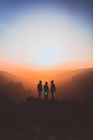 silhouette of three people at sunset by Karl Magnuson