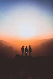silhouette of three people at sunset