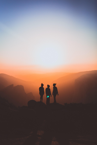 silhouette of three people at sunset by Karl Magnuson