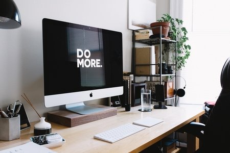 Desk with computer, plants, and office supplies