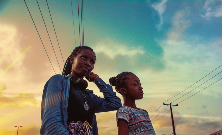 Two women with braids with the sky in the background