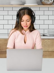 A woman (pink blouse) looking at her laptop while wearing headphones