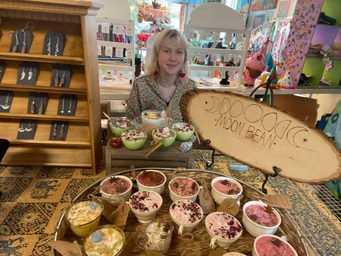 Kalli Kostival sitting at a vendors fair with her products.