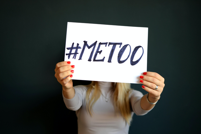woman holding paper with #metoo