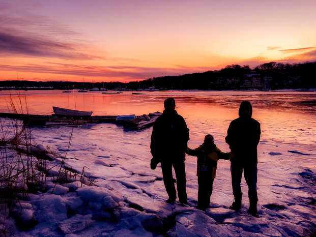 three people standing on frozen lake near boats by Josie Lopez via Unsplash