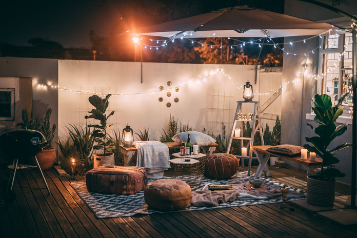patio with ottomans, tables, chairs, and lights