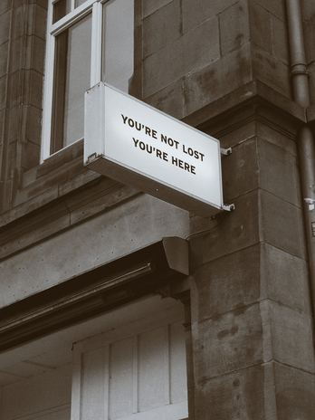 sign on the side of a building saying "YOU'RE NOT LOST YOU'RE HERE"