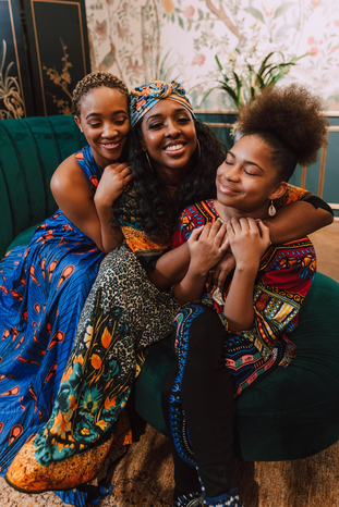 black women smiling and hugging by Rodnae productions