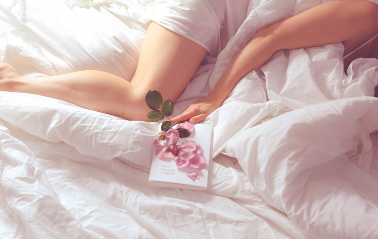 ava sol woman laying with flower resting on book while in bedjpegjpg by Ava Sol