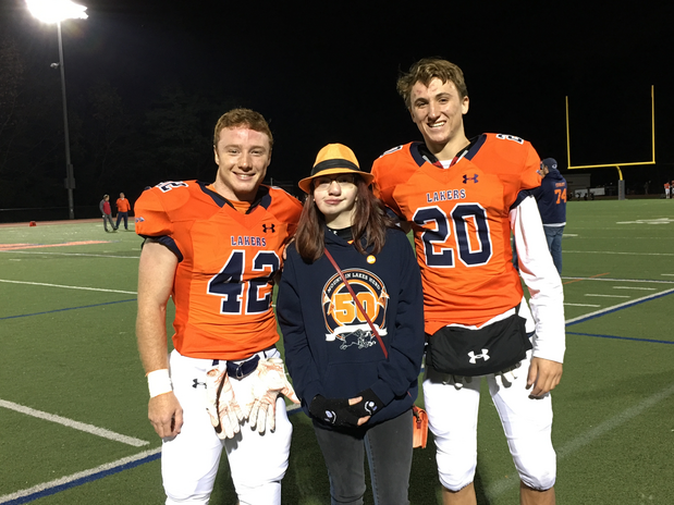 Girl in between two High School Football players