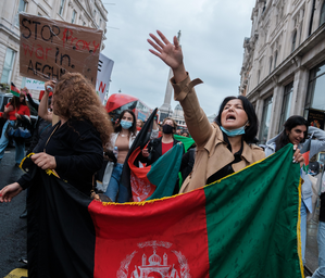 People holding Afghan flags at a protest in London.