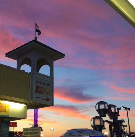 purple sky with sign that says \"rides\"