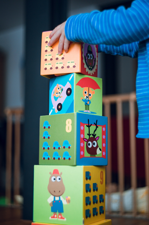 child playing with wooden blocks by Unsplash