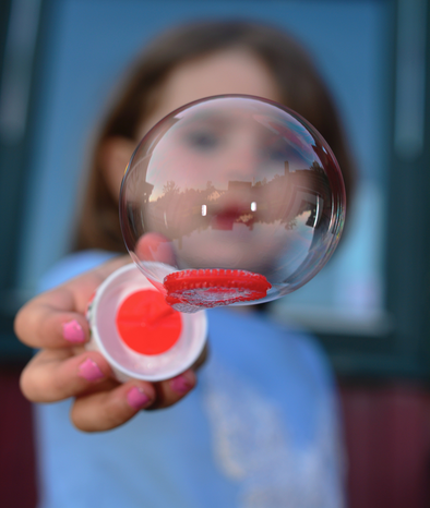 child blowing bubbles by Snapwire