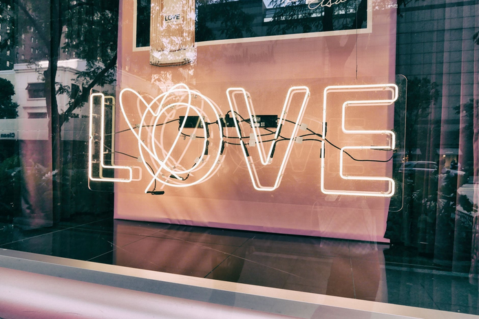 the word \"LOVE\" in a sign, lit up and in a window