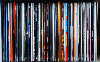 stacked vinyl records on a shelf