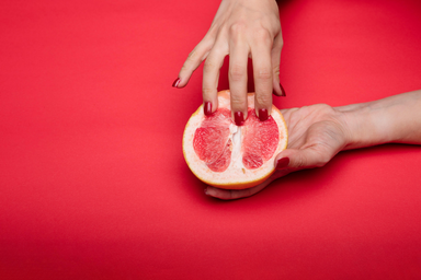Hand touching grapefruit