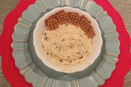 Cookie Dough Dip with Dipping Pretzels is Served in A White Bowl on top of a red and blue placemat display