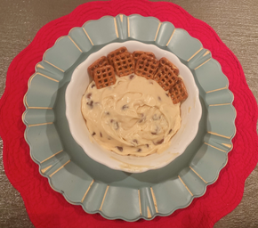 Cookie Dough Dip with Dipping Pretzels is Served in A White Bowl on top of a red and blue placemat display