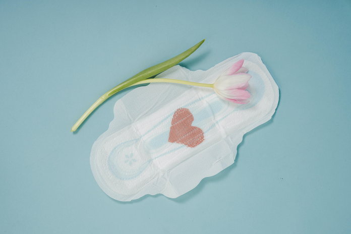 menstruation pad with a heart on it next to a flower