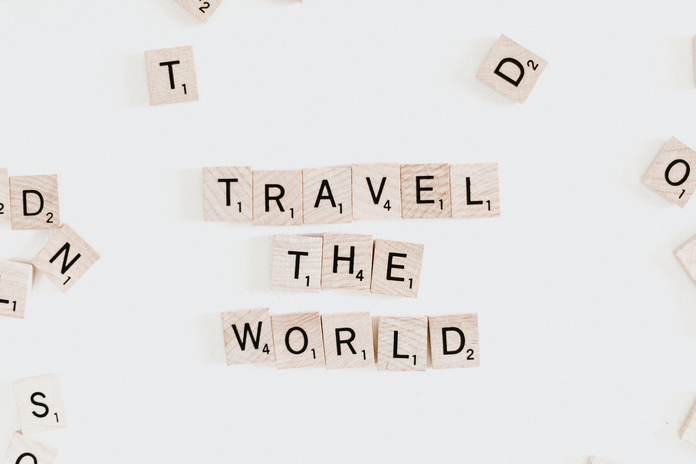 Scrabble letters spelling \"Travel the world\"